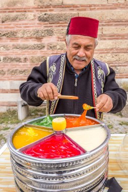 Kimliği belirsiz Osmanlı Macun (Yapıştır), Selimiye Camii ön plan ile yumuşak, tatlı ve renkli Türk şekerleme hamur satıyor. Edirne,Turkey.17 Ekim 2015
