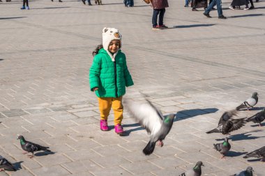 Istanbul/Türkiye-Aralık 24,2016: Yeni Camii (Yeni Camii) güvercinlerin tanımlanamayan Çocuk besleme. Yeni Camii İstanbul ' da bulunan 1665, tamamlanmış bir Osmanlı imparatorluk camiidir.