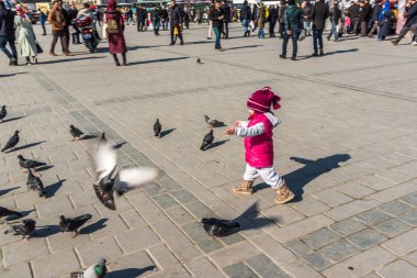 Istanbul/Türkiye-Aralık 24,2016: Yeni Camii (Yeni Camii) güvercinlerin tanımlanamayan Çocuk besleme. Yeni Camii İstanbul ' da bulunan 1665, tamamlanmış bir Osmanlı imparatorluk camiidir.