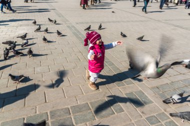Istanbul/Türkiye-Aralık 24,2016: Yeni Camii (Yeni Camii) güvercinlerin tanımlanamayan Çocuk besleme. Yeni Camii İstanbul ' da bulunan 1665, tamamlanmış bir Osmanlı imparatorluk camiidir.