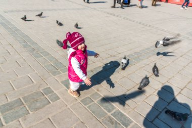 Istanbul/Türkiye-Aralık 24,2016: Yeni Camii (Yeni Camii) güvercinlerin tanımlanamayan Çocuk besleme. Yeni Camii İstanbul ' da bulunan 1665, tamamlanmış bir Osmanlı imparatorluk camiidir.