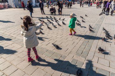 Istanbul/Türkiye-Aralık 24,2016: Yeni Camii (Yeni Camii) güvercinlerin tanımlanamayan Çocuk besleme. Yeni Camii İstanbul ' da bulunan 1665, tamamlanmış bir Osmanlı imparatorluk camiidir.