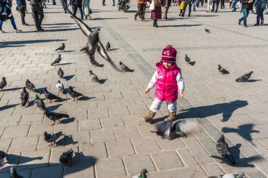 Istanbul/Türkiye-Aralık 24,2016: Yeni Camii (Yeni Camii) güvercinlerin tanımlanamayan Çocuk besleme. Yeni Camii İstanbul ' da bulunan 1665, tamamlanmış bir Osmanlı imparatorluk camiidir.