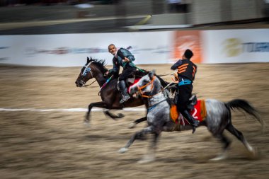 Kostümleri kimliği belirsiz kişi eski geleneksel Türk oyun oynuyor: cirit veya atarak ata sporu cirit (cirit) 28 Ağustos 2016 yılında Istanbul, Türkiye - sopa
