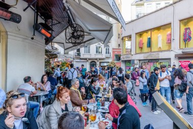 Kimliği belirsiz kişi oturup bir kafe nearf Galata Kulesi, Galata, Karaköy, Istanbul, Türkiye.29 bir Ortaçağ taş kule Nisan 2018