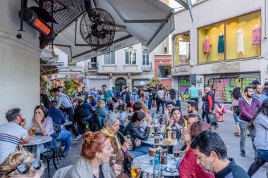 Kimliği belirsiz kişi oturup bir kafe nearf Galata Kulesi, Galata, Karaköy, Istanbul, Türkiye.29 bir Ortaçağ taş kule Nisan 2018