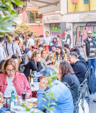 Kimliği belirsiz kişi oturup bir kafe nearf Galata Kulesi, Galata, Karaköy, Istanbul, Türkiye.29 bir Ortaçağ taş kule Nisan 2018
