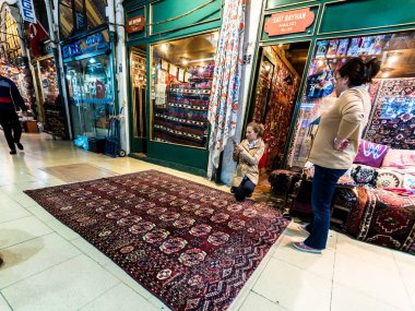Kimliği belirsiz turist kilimler ve halılar Kapalıçarşı Istanbul'da alışveriş. Grand Bazaar.Istanbul, Turkey.April 17, 2017 iç görünümü