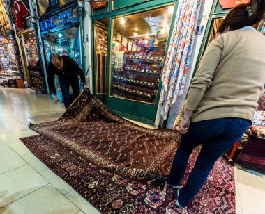 Kimliği belirsiz turist kilimler ve halılar Kapalıçarşı Istanbul'da alışveriş. Grand Bazaar.Istanbul, Turkey.April 17, 2017 iç görünümü