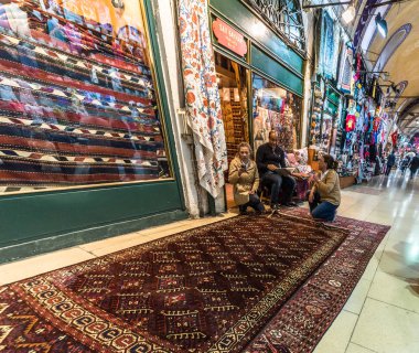 Kimliği belirsiz turist kilimler ve halılar Kapalıçarşı Istanbul'da alışveriş. Grand Bazaar.Istanbul, Turkey.April 17, 2017 iç görünümü