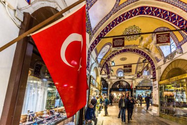 Kimliği belirsiz turist ziyaret ve Kapalıçarşı Istanbul'da alışveriş. Türk bayrağı ile kapalı çarşı iç ön plan üzerinde. Istanbul, Turkey.April 17, 201