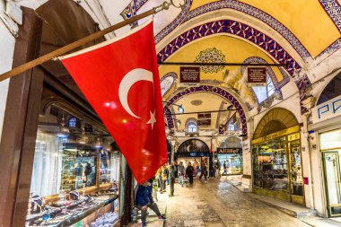 Kimliği belirsiz turist ziyaret ve Kapalıçarşı Istanbul'da alışveriş. Türk bayrağı ile kapalı çarşı iç ön plan üzerinde. Istanbul, Turkey.April 17, 201