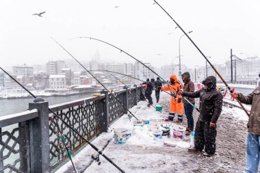 Türkiye, Istanbul, 07 Ocak 2017: Istanbul, Türkiye'de en ağır kar yağışı üzerinde galata köprüsünde Balık tutma kimliği belirsiz erkek