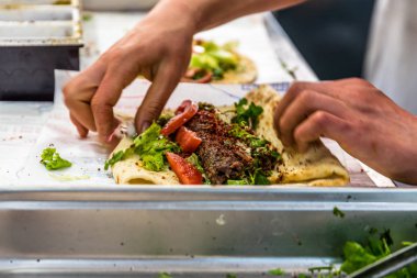Adam el hazırlanıyor lezzetli karaciğer Türk şiş kebap ızgara silindir Mini değirmenler hizmet üzerinde.