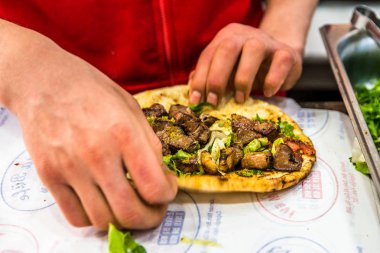 Adam el hazırlanıyor lezzetli karaciğer Türk şiş kebap ızgara silindir Mini değirmenler hizmet üzerinde.