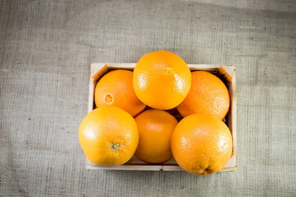 古い焦げた木枠や背景が荒布のボックスで新鮮な熟したオレンジ色の果実 ヴィンテージやレトロな効果を追加 — ストック写真