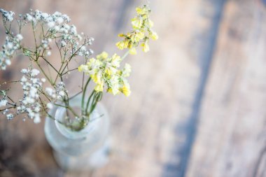 Ahşap masa, açık cam vazoda tanımlanamayan çiçekli natürmort çiçek vazo yumuşak retro görünüm