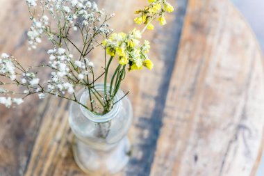 Ahşap masa, açık cam vazoda tanımlanamayan çiçekli natürmort çiçek vazo yumuşak retro görünüm