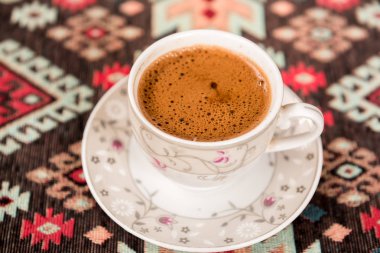 Üstten görünüm köz üzerinde pişmiş geleneksel Türk kahve, bir fincan geleneksel Türk halı üzerinde servis edilir.