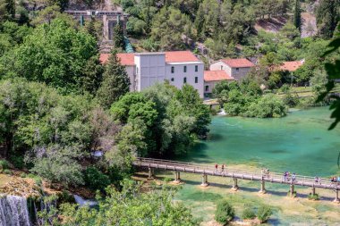 27 Mayıs 2017 şelalenin Skradinski Buk Krka Milli Parkı'nda, Sibenik, Hırvatistan, Hırvat milli parkları Köprüsü üzerinde turist yürümek