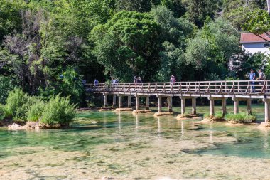 27 Mayıs 2017 şelalenin Skradinski Buk Krka Milli Parkı'nda, Sibenik, Hırvatistan, Hırvat milli parkları Köprüsü üzerinde turist yürümek