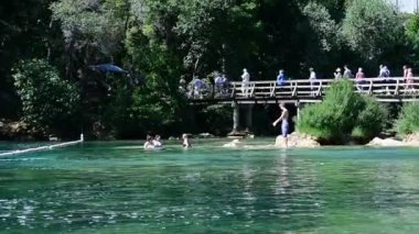 Turist köprü Krka Milli Parkı'nda en ünlü ulusal parklarından biridir üzerinde yürümek ve tarafından çok sayıda turistin ziyaret: Skradinski Buk, Milli Park Krka, Hırvatistan, 27 Mayıs 2017.