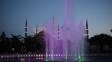 Ön plan, Sultanahmet Park, Istanbul, Türkiye'de çeşme ile Sultanahmet Camii ve gece görmek.