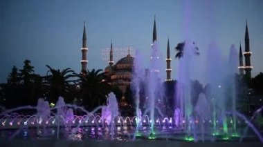 Ön plan, Sultanahmet Park, Istanbul, Türkiye'de çeşme ile Sultanahmet Camii ve gece görmek.