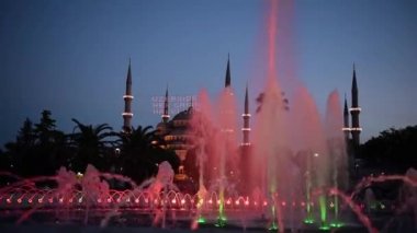 Ön plan, Sultanahmet Park, Istanbul, Türkiye'de çeşme ile Sultanahmet Camii ve gece görmek.
