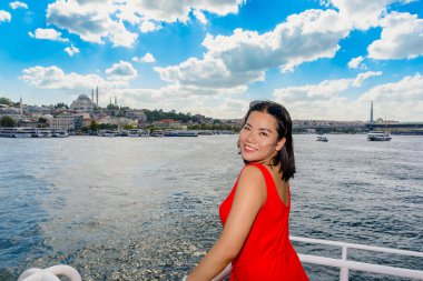 Güzel Çinli kadın Galata Köprüsü üzerinde arka plan üzerinde Süleymaniye Camii manzaralı poz veriyor.