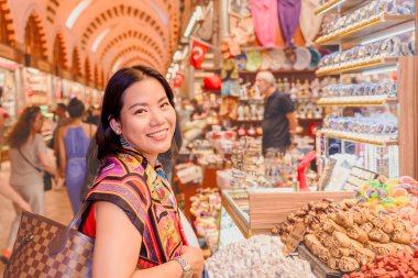 Mısır'ın Bazaarı Eminönü, Istanbul, Türkiye'de satılan geleneksel Türk tatlıları güzel Çinli kadın bakar
