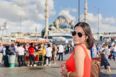 Beautiful Chinese woman poses at at Eminonu district with view of Suleymaniye mosque in Istanbul clipart