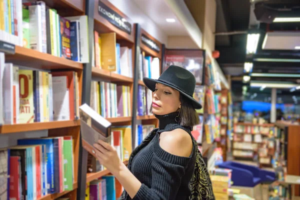 Mulher Bonita Atraente Com Chapéu Preto Vestido Olha Livros Livraria — Fotografia de Stock