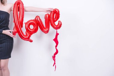 Çekici güzel model kadın elinde aşk mektubu, kırmızı balon ve kırmızı iç çamaşırı tutuyor. Beyaz arka planda sevgililer günü konsepti..