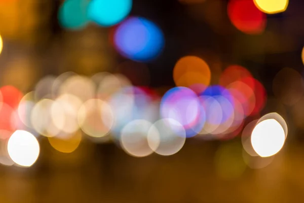 Defocused and blurred bokeh:Colorful blurred car headlights and flashing traffic lights glowing in the dark creating magical atmosphere