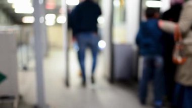 İnsanlar metro girişinde bir metal detektörü geçer. Bulanık video