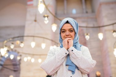 Muslim woman in headscarf and an hijab prays clipart