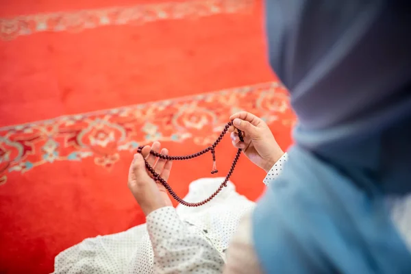 Muslim woman in headscarf and an hijab prays