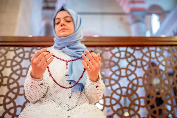 Muslim woman in headscarf and an hijab prays