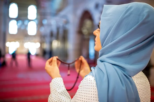 Muslim woman in headscarf and an hijab prays