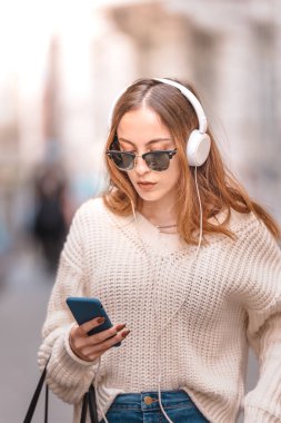 Güzel genç kız yürürken müzik dinler