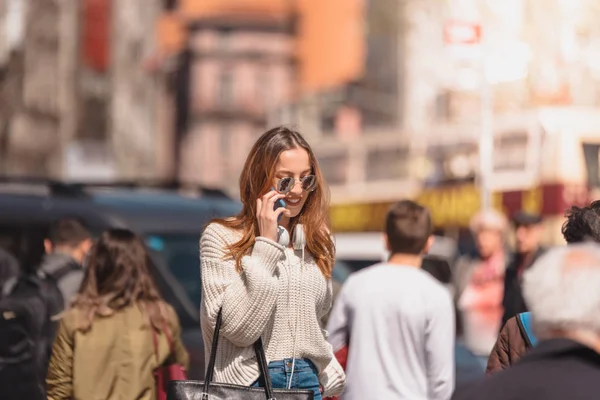 Mooie vrouw maakt gebruik van smartphone tijdens het lopen — Stockfoto