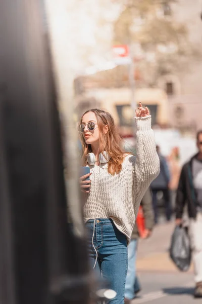 Vacker kvinna söker en taxi på gatan — Stockfoto