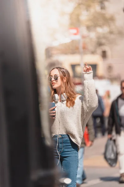 Mulher bonita procura um táxi na rua — Fotografia de Stock