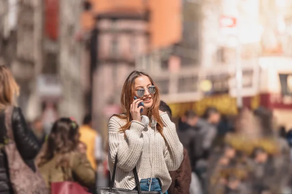 Mooie vrouw maakt gebruik van smartphone tijdens het lopen — Stockfoto