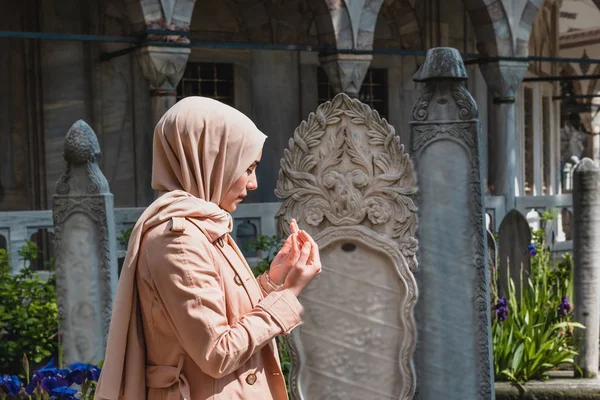 Muslim woman in headscarf and and hijab prays