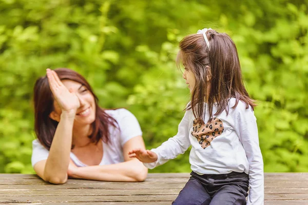 Young mom and her little girl have fun together