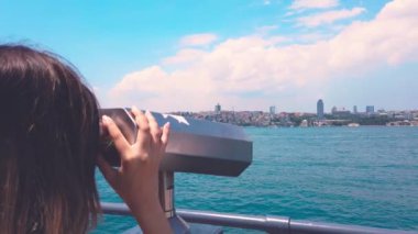 Güzel kız, Istanbul 'da, Üsküdar 'da popüler bir hedef olan Boğaz 'da Gezilen dürbün üzerinden bakıyor