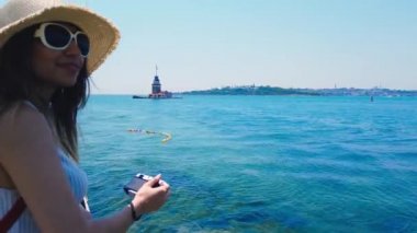 Güzel kız, Üsküdar kasabasında Bosphorus and Maidens Kulesi resimlerini çeker, Istanbul, Türkiye