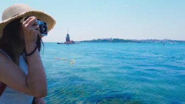 Güzel kız, Üsküdar kasabasında Bosphorus and Maidens Kulesi resimlerini çeker, Istanbul, Türkiye